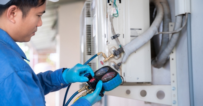Nhân viên kỹ thuật đang nạp thêm gas cho máy lạnh